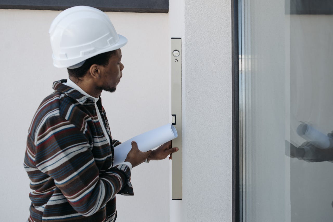 Architect using a level for construction checks, wearing safety helmet.